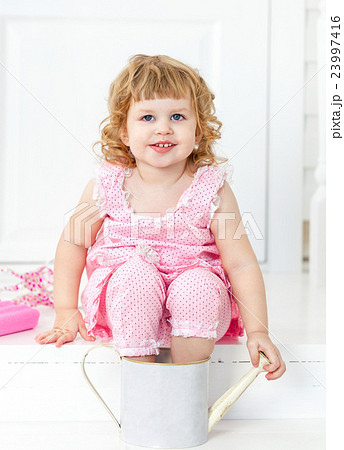 Little cute curly girl sitting on porch Provence Little cute curly girl sitting on porch Provence 23997416
