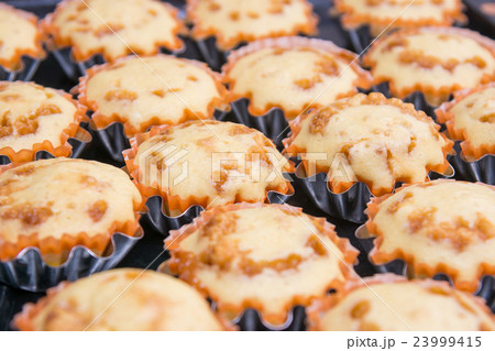 Freshly baked muffins in metal tins Freshly baked muffins in metal tins 23999415