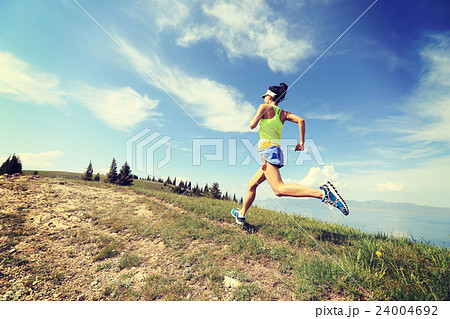 young woman trail runner running on mountain peak young woman trail runner running on mountain peak 24004692