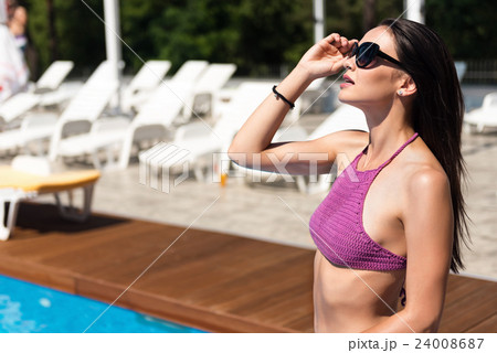 Delighted beautiful woman resting near swimming Delighted beautiful woman resting near swimming 24008687