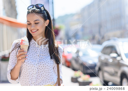 Happy girl enjoying sweet food outdoors 24009868