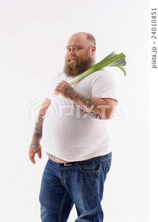 Bearded male fatso holding leek Bearded male fatso holding leek 24010851
