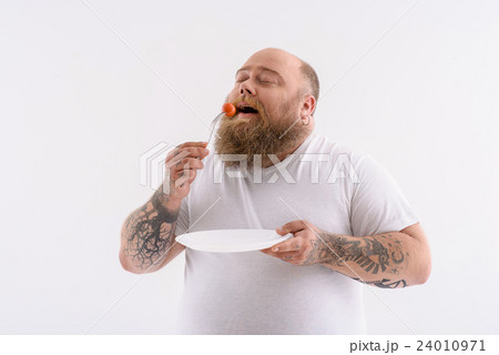 Hungry thick guy eating tiny vegetable Hungry thick guy eating tiny vegetable 24010971