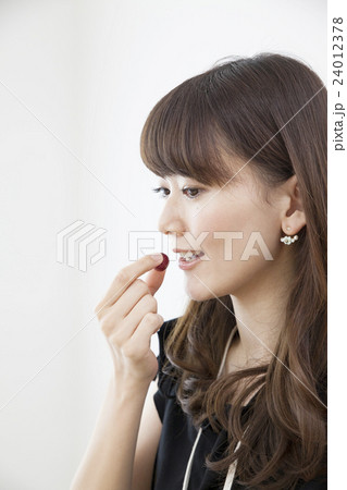 仕事中に間食する代女性 グミの写真素材