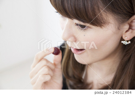 仕事中に間食する代女性 グミの写真素材