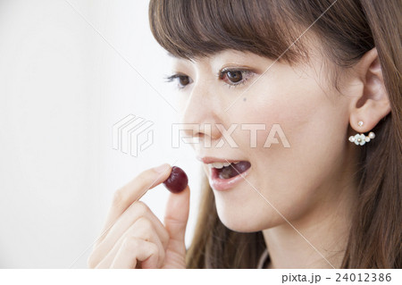 仕事中に間食する20代女性_グミ 24012386