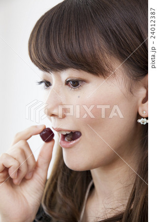 仕事中に間食する20代女性_グミ 24012387