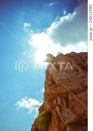 Steep rocks with place against sun sky backlight 24012980