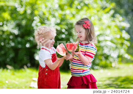 Kids eating watermelon in the garden Kids eating watermelon in the garden 24014724
