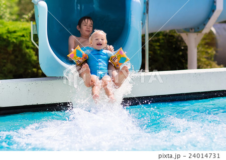Kids on a water slide in swimming pool 24014731