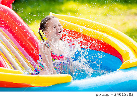 Little girl in garden swimming pool Little girl in garden swimming pool 24015582