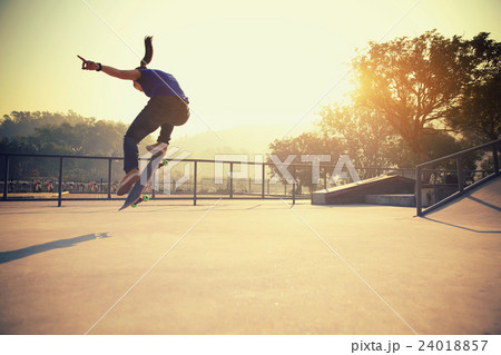 skateboarding woman practice ollie at skatepark 24018857
