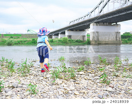 河原で石投げをする子供の写真素材