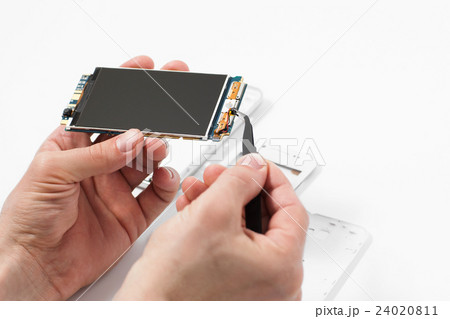 Repairman disassembling smartphone with tweezers Repairman disassembling smartphone with tweezers 24020811