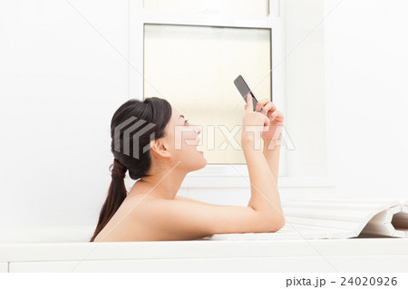 お風呂でスマホをいじる女性 24020926