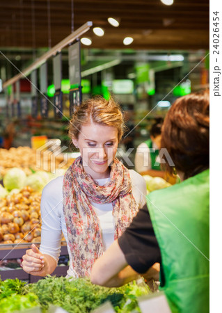 Portrait of beautiful young woman choosing green leafy vegetable 24026454