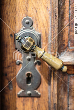 Antique door handle on an old wooden door Antique door handle on an old wooden door 24031572