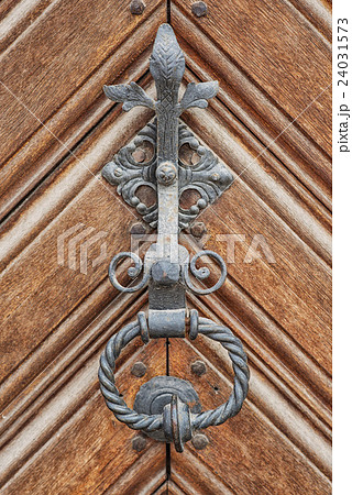 Antique door knocker on an old wooden door 24031573