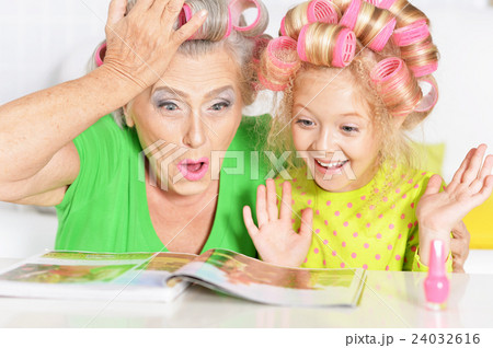 Senior woman and granddaughter painting nails Senior woman and granddaughter painting nails 24032616