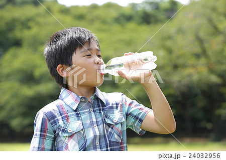 ペットボトルの水を飲む少年の写真素材