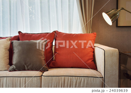 Red and brown pillows on beige sofa in living room 24039639