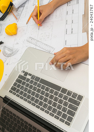 Hand over Construction plans with yellow helmet and drawing tools on blueprints . Hand over Construction plans with yellow helmet and drawing tools on blueprints . 24043767