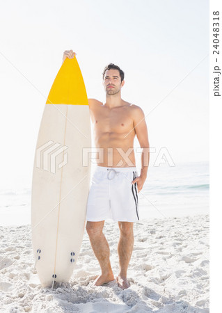 Man holding surfboard on the beach Man holding surfboard on the beach 24048318
