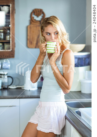 Beautiful woman having coffee in kitchen 24048404