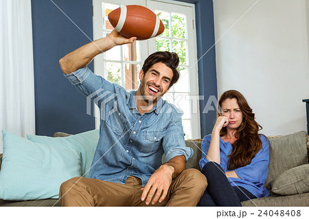 Couple watching american football match on television 24048408