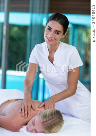 Woman receiving back massage from masseur Woman receiving back massage from masseur 24048415