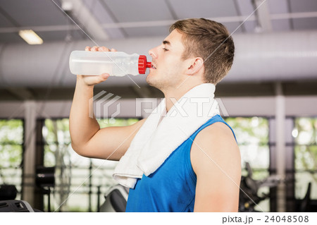 Man on treadmill drinking water at gym 24048508