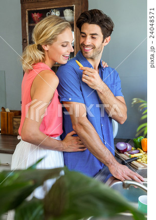 Man feeding his woman in kitchen 24048571