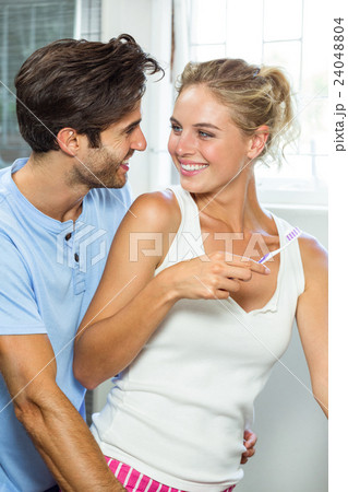 Couple hugging while brushing teeth Couple hugging while brushing teeth 24048804