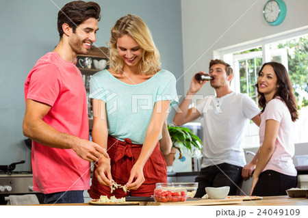 Couple preparing food while friends in background 24049109