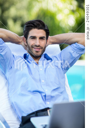Smart man with a laptop relaxing on sun lounger 24049301