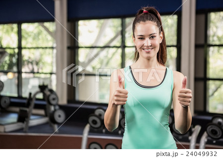 Woman showing her thumbs up at gym Woman showing her thumbs up at gym 24049932