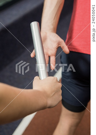 Athlete passing a baton to the partner Athlete passing a baton to the partner 24050041