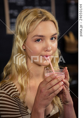 Woman drinking a milkshake 24050144
