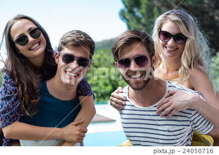 Two men giving a piggy back to women Two men giving a piggy back to women 24050716