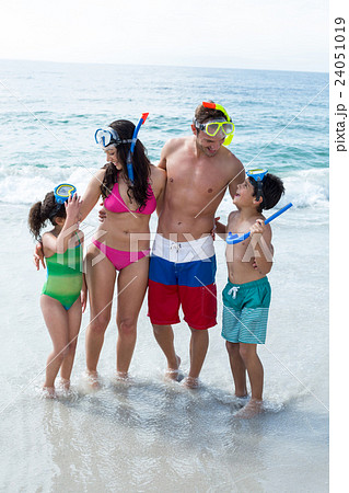 Family wearing diving goggles standing on sea shore Family wearing diving goggles standing on sea shore 24051019