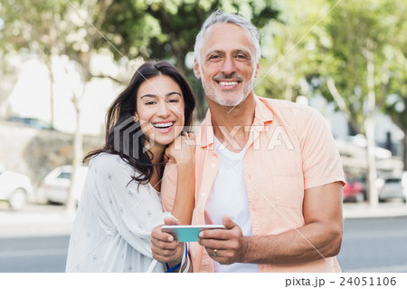 Cheerful couple using phone 24051106