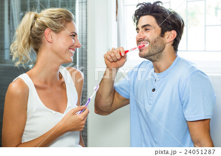 Couple brushing their teeth in bathroom Couple brushing their teeth in bathroom 24051287