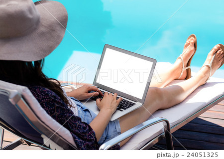 Woman sitting on deckchair using laptop Woman sitting on deckchair using laptop 24051325