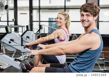 Portrait of a man and woman working out on rowing machine Portrait of a man and woman working out on rowing machine 24051569