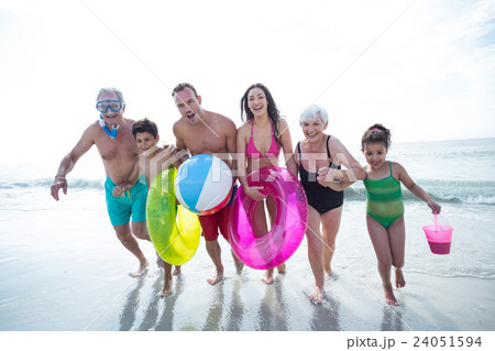 Happy multi-generation family running at beach Happy multi-generation family running at beach 24051594