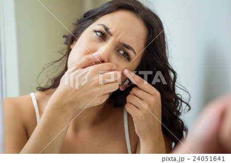 Woman popping her pimple Woman popping her pimple 24051641
