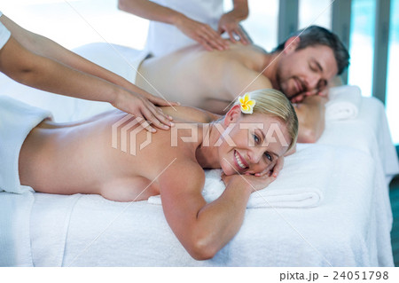 Young couple receiving a back massage from masseur Young couple receiving a back massage from masseur 24051798