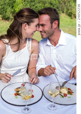Smiling young couple sitting in lawn Smiling young couple sitting in lawn 24052236