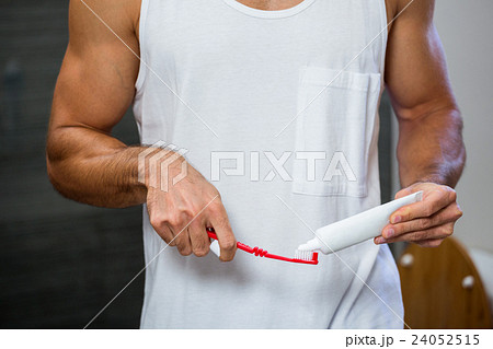 Man squeezing toothpaste on toothbrush 24052515