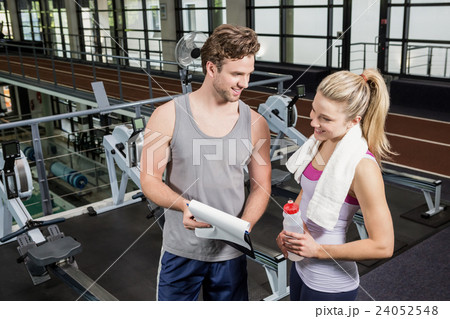 Woman talking to her trainer after a workout Woman talking to her trainer after a workout 24052548